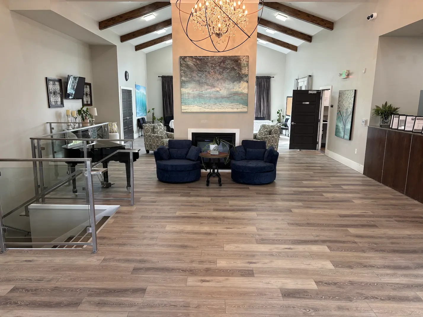 Spacious, upscale treatment facility lobby with modern furnishings, vaulted ceilings, chandelier lighting, and comfortable lounge seating.